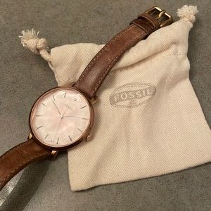 Slightly worn Fossil woman’s watch with rose gold details and a light brown band